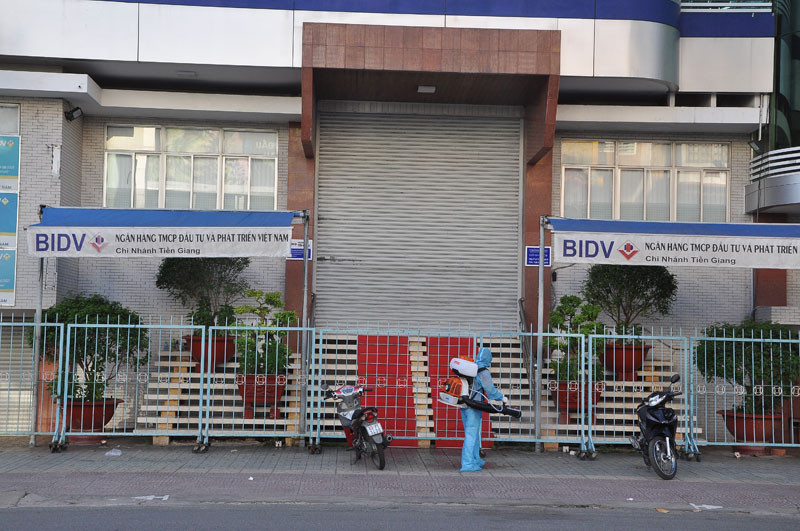Lực lượng chức năng phun khử trùng tại Ngân hàng BIDV chi nhánh Tiền Giang sáng 27/6.
