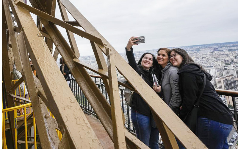 Du khách hào hứng chụp ảnh với toàn ảnh thành phố Paris từ Tháp Eiffel (Ảnh: AP)