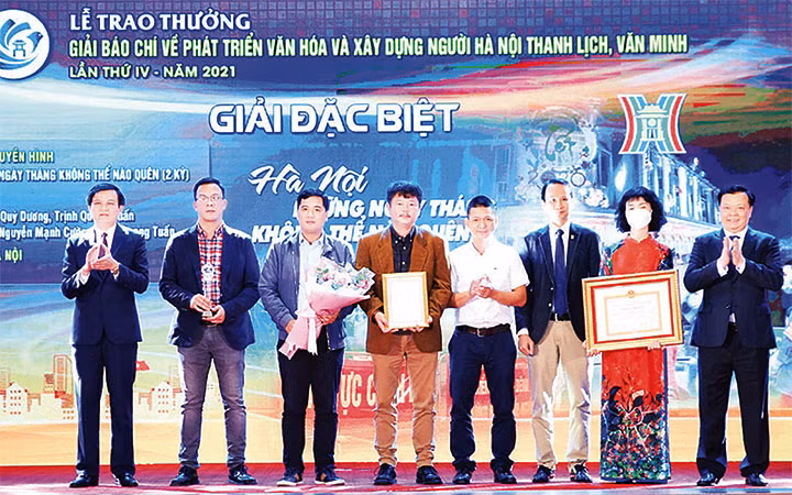 Bí thư Thành ủy Hà Nội Đinh Tiến Dũng, Tổng Biên tập Tạp chí Cộng sản Đoàn Minh Huấn trao giải đặc biệt Giải Báo chí về phát triển văn hóa và xây dựng người Hà Nội thanh lịch, văn minh cho nhóm tác giả Đài Phát thanh - Truyền hình Hà Nội. (Ảnh: Thành Nguyễn)