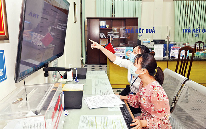 Người dân sử dụng dịch vụ công trực tuyến tại bộ phận “một cửa” UBND phường Trung Hòa, quận Cầu Giấy.  (Ảnh: Duy Đăng)