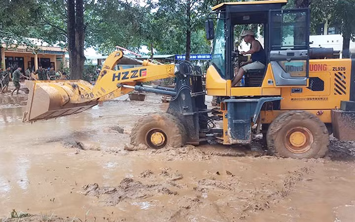 Phụ huynh đưa xe ủi đến giúp Trường tiểu học - THCS Cam Tuyền, huyện Cam Lộ (Quảng Trị) dọn bùn sau lũ. Ảnh: LÂM QUANG HUY