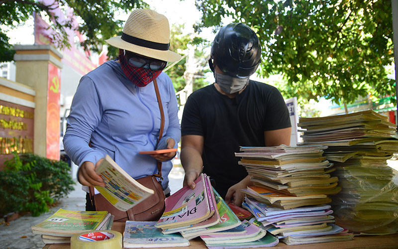 Chị Anh Hà (trái) lựa sách cho em Hoàng Long.