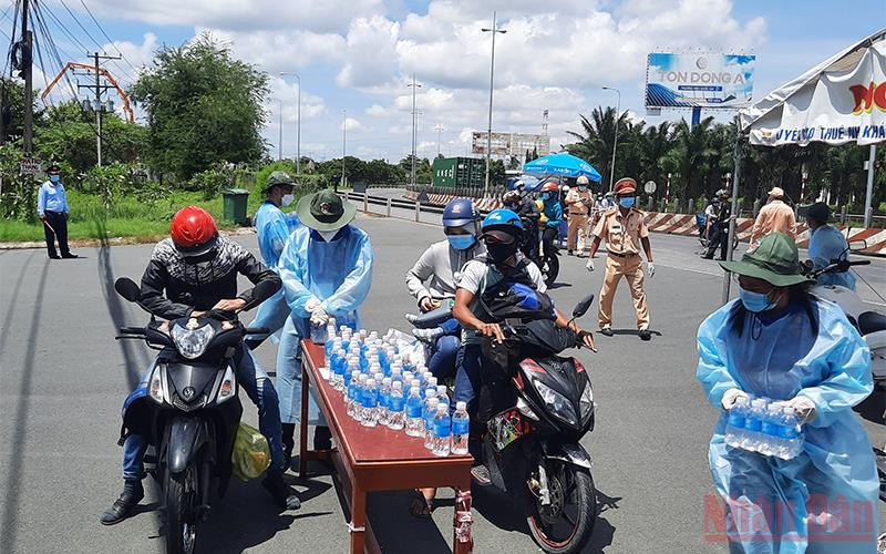 Tuổi trẻ Vĩnh Long hỗ trợ nước uống cho những người dân ngoài tỉnh tại chốt kiểm soát dịch bệnh số 1. (Ảnh: Bá Dũng)