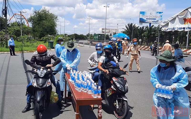 Tuổi trẻ Vĩnh Long hỗ trợ nước uống cho những người dân ngoài tỉnh tại chốt kiểm soát dịch bệnh số 1. (Ảnh: Bá Dũng)