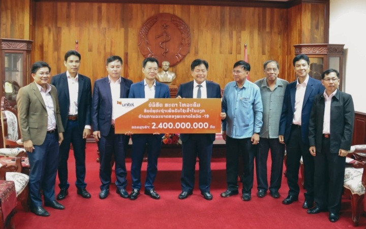 Bộ trưởng Y tế Lào Bounkong Sihavong (giữa) nhận tượng trưng 2,4 tỷ kíp Lào của Tổng Giám đốc Công ty Star Telecom Lưu Mạnh Hà.