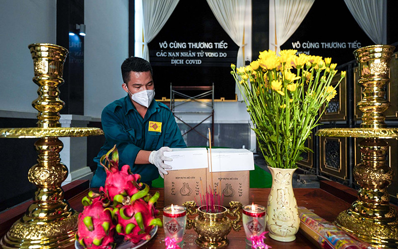 Một chiến sĩ dân quân tự vệ thắp hương cho một nạn nhân tử vong trong dịch Covid-19. Ảnh: Hoàng Triều.