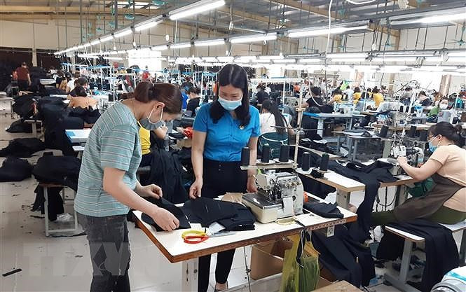 Công nhân Công ty TNHH May Nien Hsing Ninh Bình, khu công nghiệp Khánh Phú, huyện Yên Khánh, Ninh Bình sản xuất trong mùa dịch. (Ảnh: TTXVN).