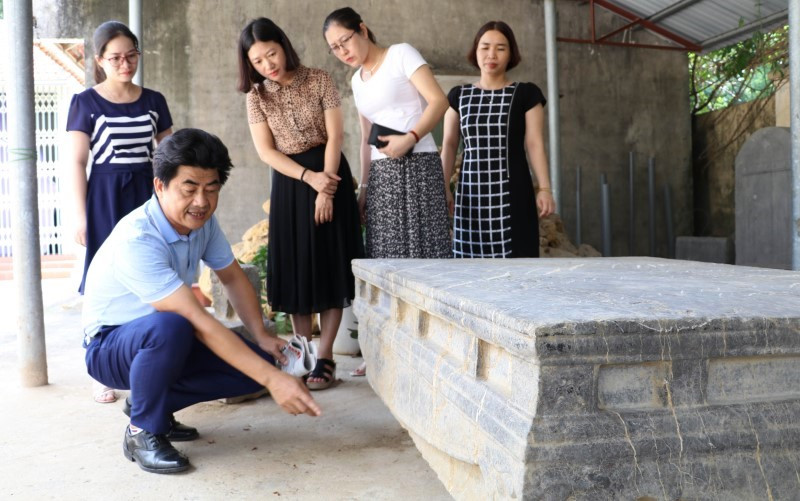 Cán bộ Bảo tàng Ninh Bình nghiên cứu họa tiết, hoa văn trên sập đá cổ, phát hiện ở xã Xích Thổ, huyện Nho Quan (Ninh Bình).