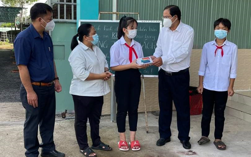 Phó Bí thư Thường trực Huyện ủy Châu Đức Nguyễn Tấn Bản (thứ 2, từ phải qua) trao thiết bị hỗ trợ học online cho em Nguyễn Uyên Nhi, học sinh lớp 7A3, Trường THCS Võ Trường Toản.