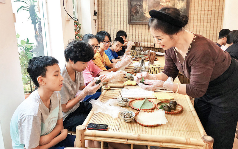 Bà Nguyễn Thị Hiền hướng dẫn thiếu nhi làm món bún ốc nguội.
