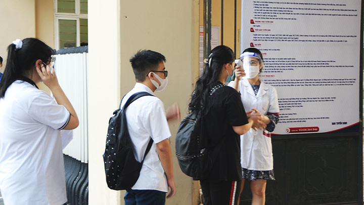 Kiểm tra thân nhiệt của thí sinh trước khi vào phòng thi. Ảnh: N.ANH