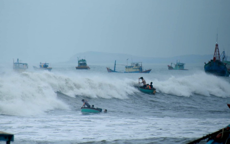 Sóng lớn đánh phủ lên các tàu thuyền neo đậu tại bãi ngang xã Chí Công, huyện Tuy Phong (Bình Thuận).