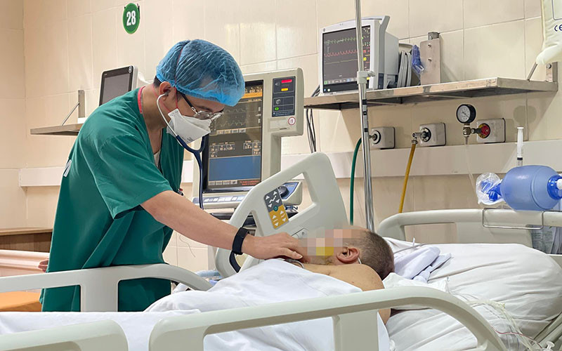 TS, BS Phạm Tiến Quân, Trưởng Khoa Hồi sức tích cực tim mạch và lồng ngực thăm khám cho bệnh nhân sau phẫu thuật.