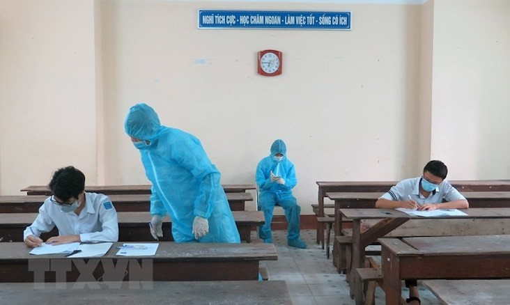 Hai thí sinh trong khu vực phong toả ở Phú Yên được bố trí phòng thi riêng, cán bộ coi thi mặc đồ bảo hộ. Ảnh: XUÂN TRIỆU/TTXVN