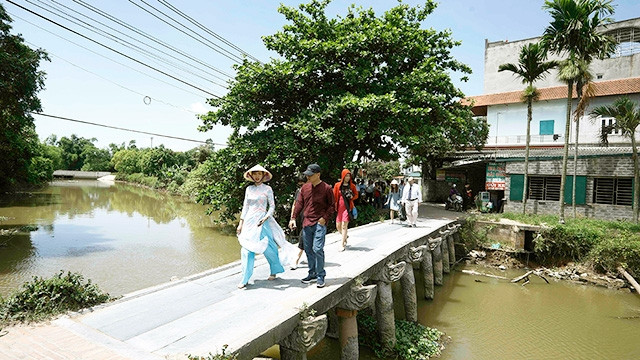 Khách du lịch thăm cầu đá làng Nôm.