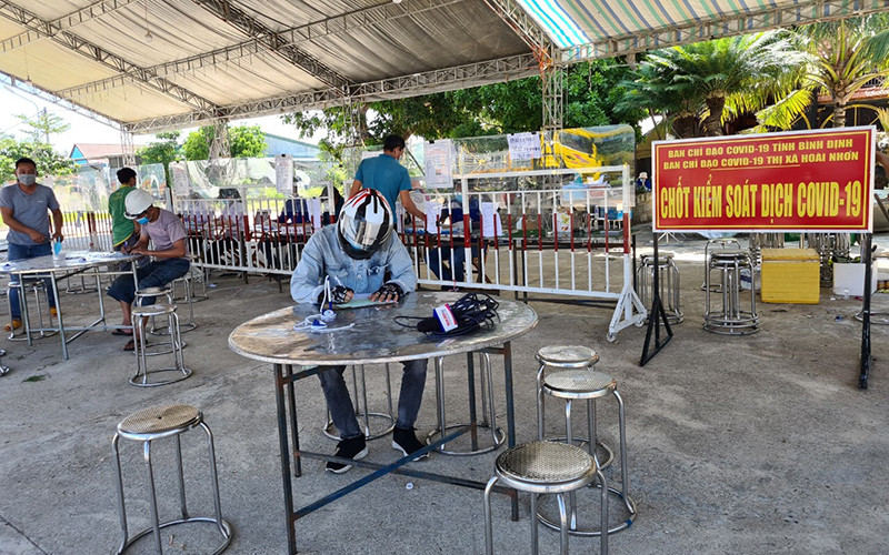 Người dân khai báo y tế tại chốt kiểm soát dịch bệnh trên Quốc lộ 1 A đoạn thị xã Hoài Nhơn, tỉnh Bình Định.