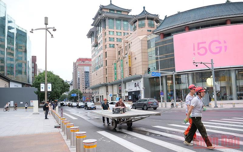 Người lao động không đeo khẩu trang đi qua một ngã tư. (Ảnh: VI SA)