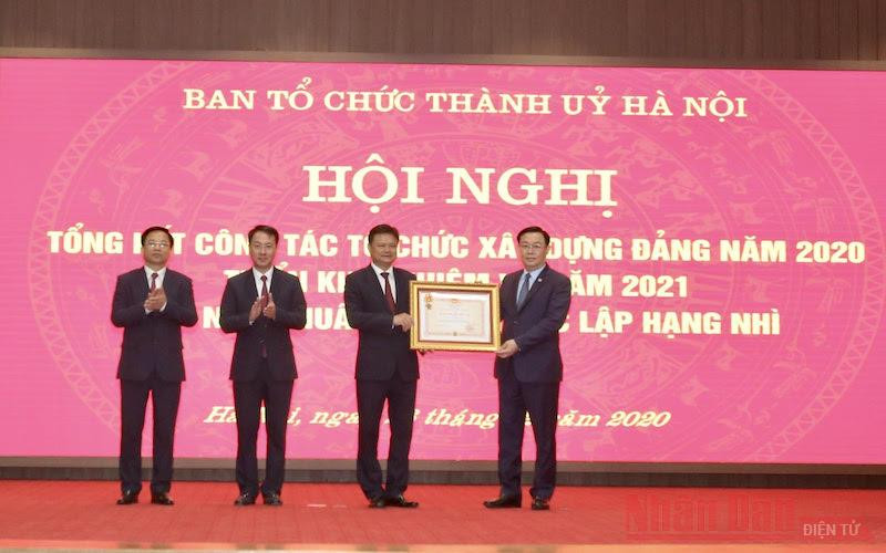Đồng chí Vương Đình Huệ, Ủy viên Bộ Chính trị, Bí thư Thành ủy Hà Nội trao Huân chương Độc lập hạng Nhì cho Ban Tổ chức Thành ủy Hà Nội. (Ảnh: Duy Linh)