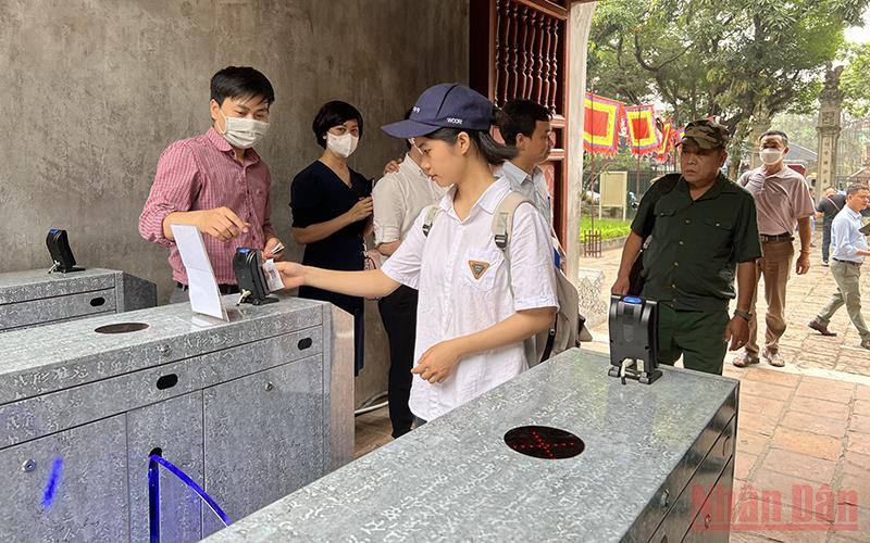 Khách du lịch quẹt thẻ để vào tham quan di tích Văn Miếu - Quốc Tử Giám.