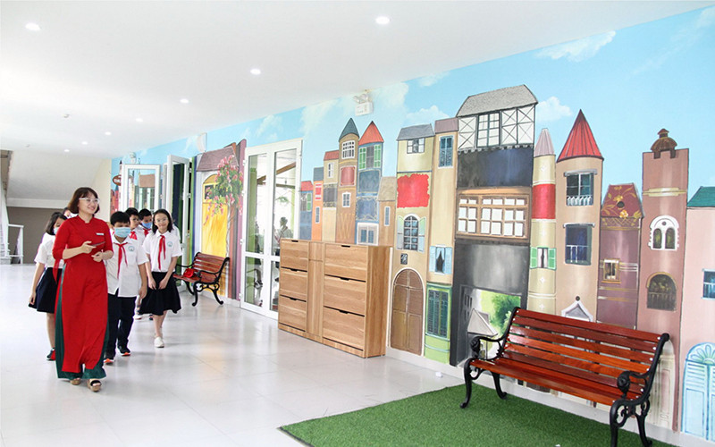 Cô giáo Phạm Thanh Minh hướng dẫn học sinh học tập, đọc sách tại thư viện trường. 