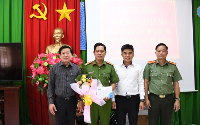 Đồng chí Nguyễn Văn Nhựt, Phó Giám đốc Ngân hàng Nhà nước Việt Nam chi nhánh Tiền Giang và đồng chí Nguyễn Hồng Khắc, Phó Giám đốc Công an Tiền Giang trao hoa, quà cho tập thể Công an TP Mỹ Tho.