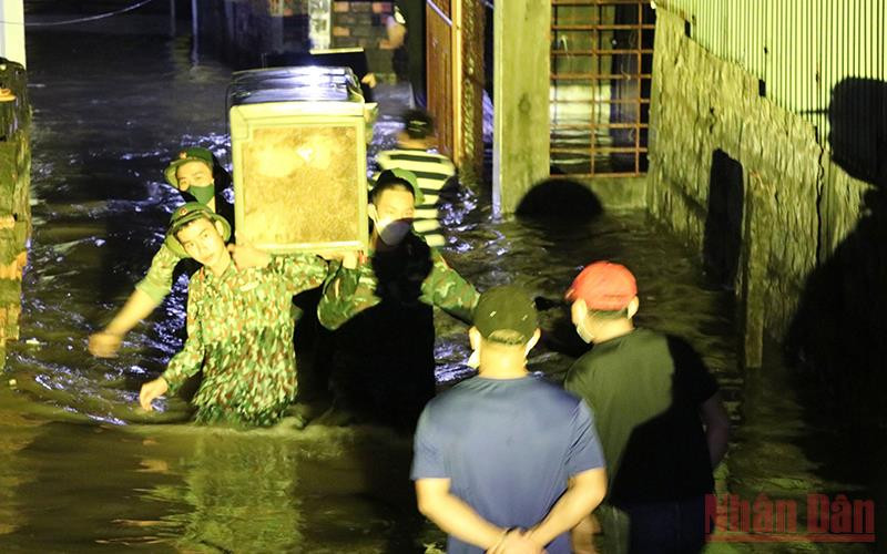 Cán bộ chiến sĩ Bộ chỉ huy Quân sự tỉnh Phú Yên giúp người dân có nhà bị triều cường gây ngập đến nơi an toàn.