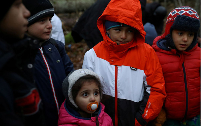 Trẻ em trong một đoàn người di cư tập trung tại một khu rừng gần biên giới Ba Lan - Belarus. (Ảnh Reuters)