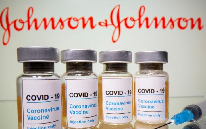 Lọ vaccine ngừa Covid-19 được chụp trước biểu trưng của Johnson & Johnson. Ảnh: Reuters.