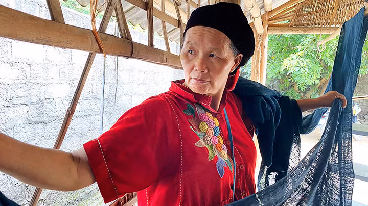 Bà Vàng Thị Mai đang phơi vải lanh ở Hợp tác xã Hợp Tiến.