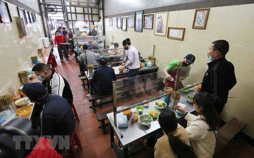 Quán ăn trong nhà lắp tấm chắn giữa các vị trí ngồi bảo đảm phòng, chống dịch Covid-19. (Ảnh: TTXVN)