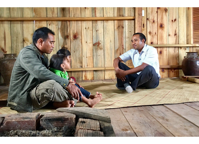 Cán bộ đến nhà dân để tuyên truyền, vận động đưa trẻ đến trường.