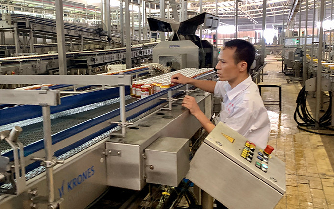 Công nhân Nhà máy bia Hà Nội - Mê Linh vận hành dây chuyền sản xuất bia lon.