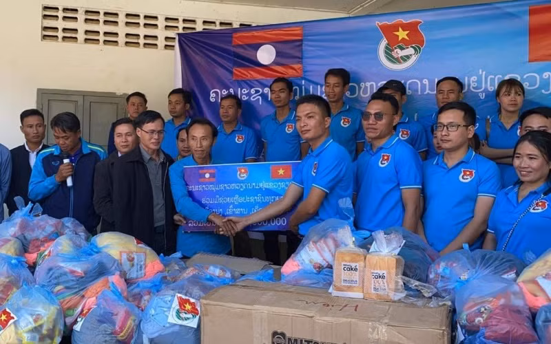 Ông Giang Công Huân (phải) tại buổi lễ trao ủng hộ các gia đình khó khăn tại xã Namka, huyện Phaxay, tỉnh Xiengkhuang. (Ảnh: Hội Thanh niên Việt Nam tỉnh Xiengkhuang)