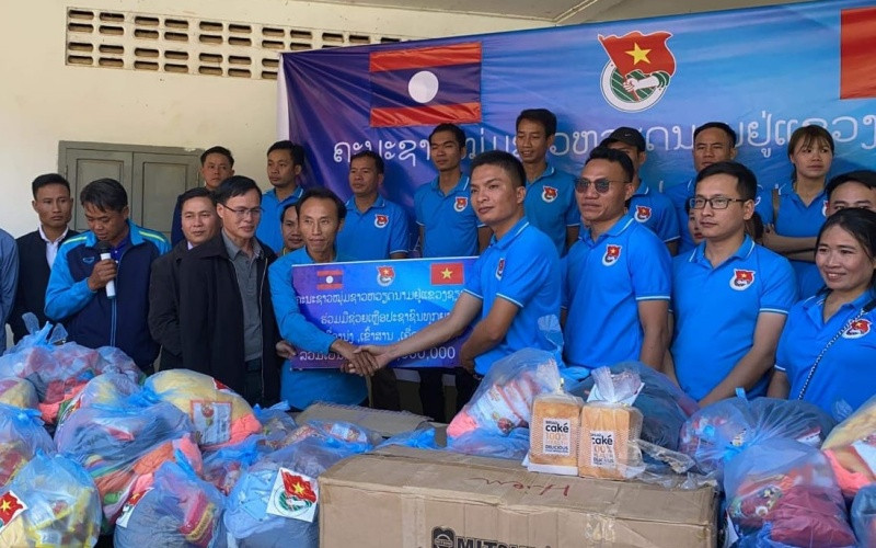 Ông Giang Công Huân (phải) tại buổi lễ trao ủng hộ các gia đình khó khăn tại xã Namka, huyện Phaxay, tỉnh Xiengkhuang. (Ảnh: Hội Thanh niên Việt Nam tỉnh Xiengkhuang)