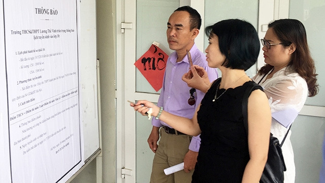 Phụ huynh học sinh tìm hiểu thông tin tại một trường THPT. Ảnh: HẢI NAM