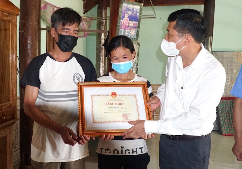 Trao Bằng khen của Bộ GD-ĐT cho gia đình em Lương Mạnh Tuấn. Ảnh: MH