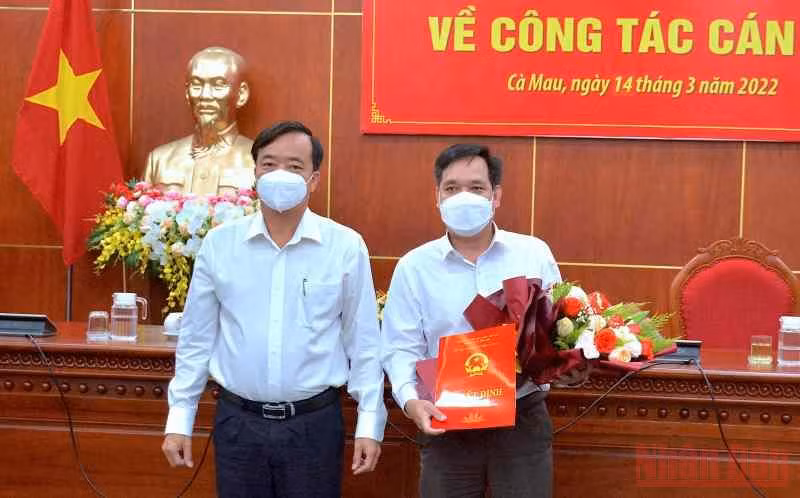 Chủ tịch Ủy ban nhân dân tỉnh Cà Mau (bìa trái) trao quyết định và tặng hoa chúc mừng tân Chánh Văn phòng Ủy ban nhân dân tỉnh.