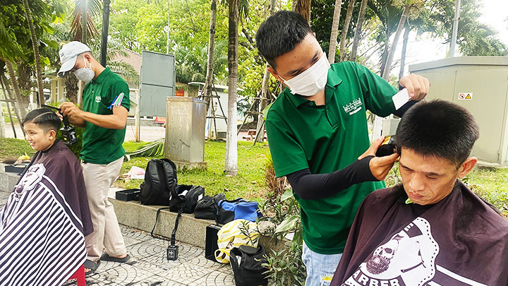 Hai bạn trẻ của tiệm Bin & Homie Barber đang cắt tóc miễn phí cho người dân.