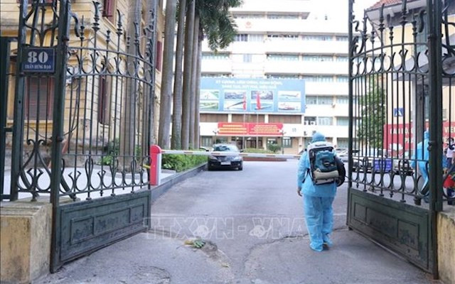 Lực lượng y tế tiến hành phun khử khuẩn tại trụ sở Bộ Giao thông vận tải. (Ảnh: Hoàng Hiếu/TTXVN)