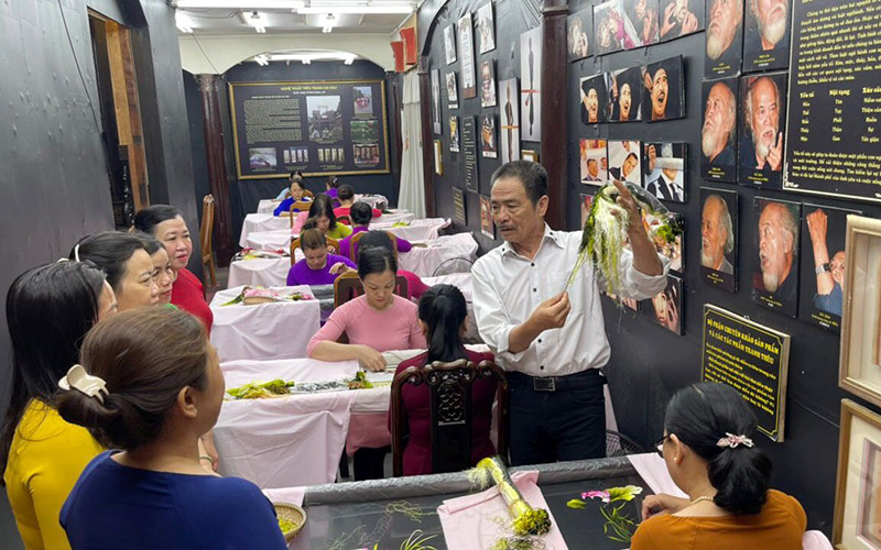 Anh Võ Văn Quân và các nghệ nhân thêu XQ trao đổi về chủ đề tác phẩm một bức tranh thêu. 