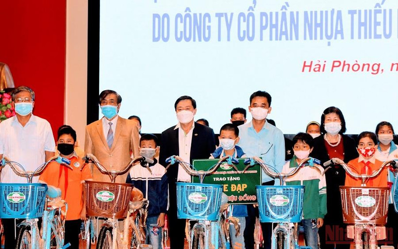 Đại diện Công ty cổ phần Nhựa Tiền Phong trao tặng xe đạp cho các em học sinh có hoàn cảnh khó khăn. (Ảnh: NGÔ QUANG DŨNG) 