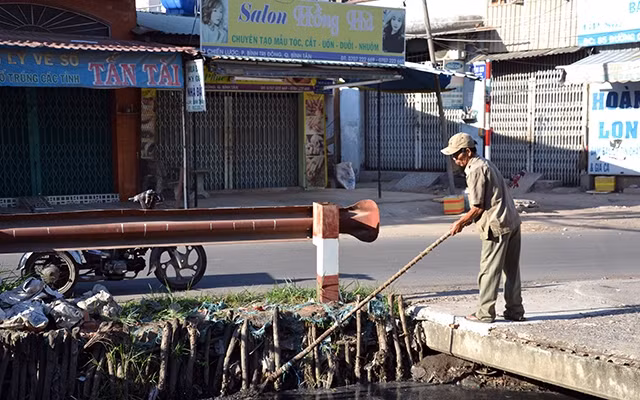 Ông Nguyễn Ngọc Ðức vớt rác trên kênh Chiến Lược.
