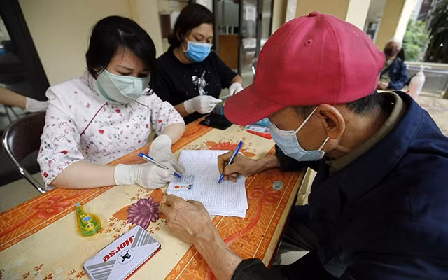 Người dân ở quận Đống Đa, Hà Nội nhận tiền hỗ trợ từ gói hỗ trợ an sinh xã hội của Chính phủ (Ảnh minh họa: Duy Linh).