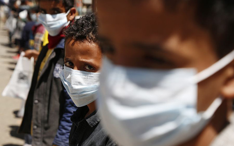 Trẻ mồ côi đeo khẩu trang nhận đồ hỗ trợ tại trại trẻ mồ côi ở Sanaa, Yemen. (Ảnh: Xinhua/TTXVN)