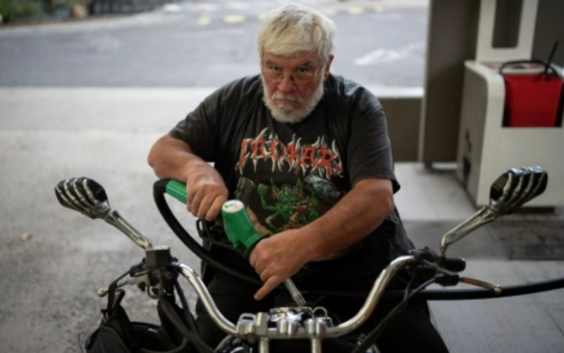 Một người lái xe máy đổ xăng tại trạm nhiên liệu. (Ảnh: AP)