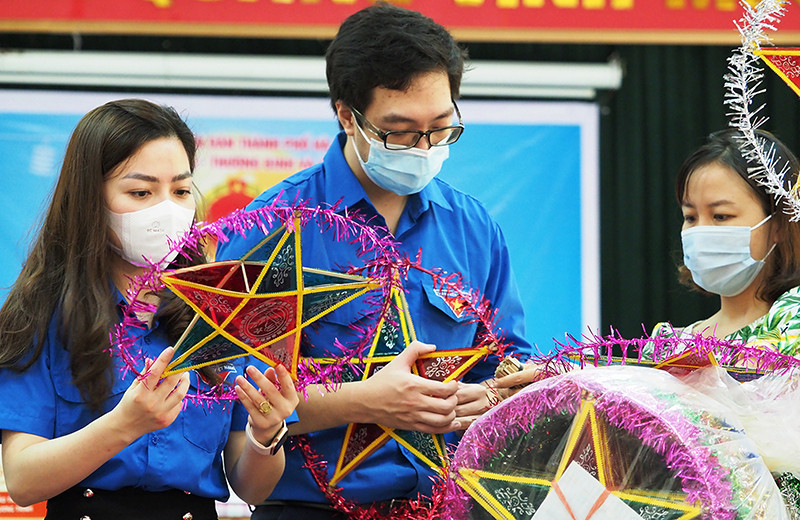 Các tình nguyện viên làm đèn ông sao tặng các em thiếu nhi tại Trung tâm Nuôi dưỡng người già và trẻ tàn tật Hà Nội.