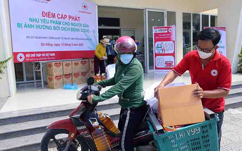 Hỗ trợ người dân mang nhu yếu phẩm về.