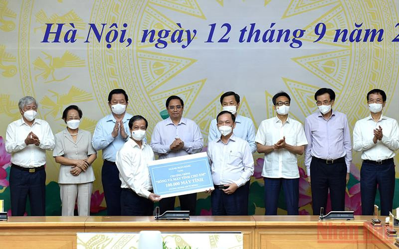 Thủ tướng Phạm Minh Chính và nhiều lãnh đạo chứng kiến các đơn vị trao tặng máy tính cho chương trình. (Ảnh: TRẦN HẢI)