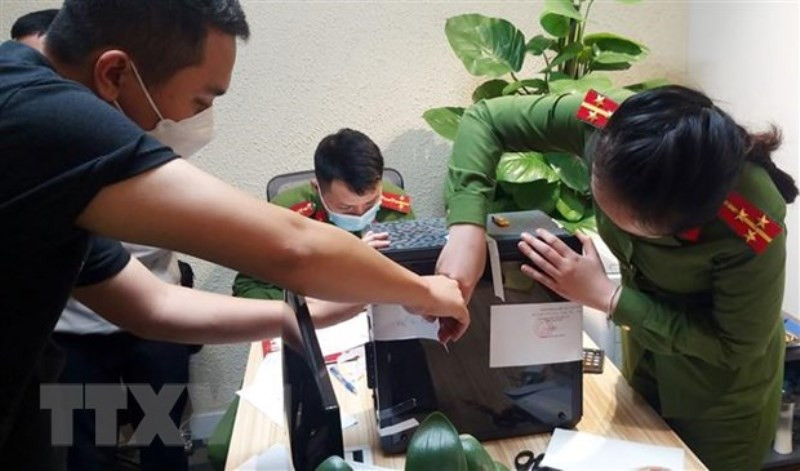 Lực lượng chức năng khám xét và niêm phong, thu giữ tài liệu tại trụ sở FLC. (Ảnh: TTXVN)