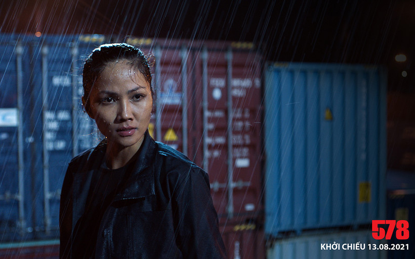 H' Hen Niê dầm mưa trong cảnh quay tại bến cảng.